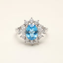 Azure Halo adjustable S925 sterling silver ring with 7 × 9 mm oval blue topaz and clear halo accents.