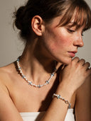 Model styling the matching Azure Horizon necklace and bracelet set, showcasing the synergistic energy of Blue Topaz and pearls for a complete aura shield.