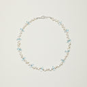 Studio shot of a consecrated Yue TerraBrio necklace with luminous 3D-cut Blue Topaz droplets and precision-drilled double-sided Baroque pearls on 925 sterling silver.