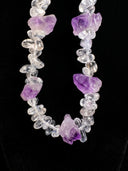 Detailed view of the clear quartz and amethyst bead texture on black fabric.