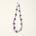 Crystalline Stillness clear quartz chip and amethyst necklace arranged on a cream background.