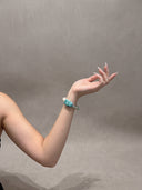 Model wearing the Glacial Sovereignty amazonite, labradorite, and pearl bracelet against a soft gray background.