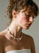 Model wearing the Yue TerraBrio Bridge of Wisdom necklace, showcasing the eclectic organic textures and vibrant mineral tones against neutral-toned attire.