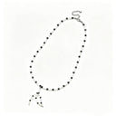 Pale Sentinel white trochus shell and black spinel necklace with a hand-shaped shell pendant on a white background.