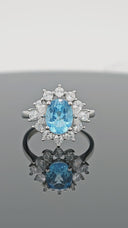 Different angled view of Azure Halo adjustable S925 sterling silver ring with oval blue topaz and floral halo setting.