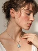 Yue TerraBrio model wearing the Quiet Compass aquamarine and zircon pendant necklace on a silver-tone chain.