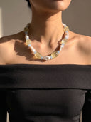 Model wearing the citrine, aquamarine, and baroque pearl necklace with a black off-the-shoulder top.