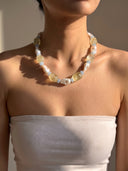 Model wearing the citrine, aquamarine, and baroque pearl necklace with a white strapless top.