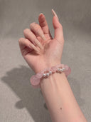 Close-up of the Yue TerraBrio Rose Softness rose quartz and shell pearl bracelet worn on the wrist.