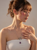 Model wearing the Violet Orbit longline amethyst and zircon safety pin necklace from Yue TerraBrio, paired with a strapless white top.