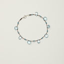 Yue TerraBrio Azure Current bracelet with blue topaz drop beads, faceted topaz accents, hand-knotted cord, and an S925 sterling silver spring clasp.