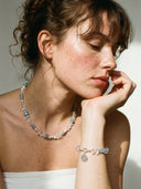 Model wearing Yuè TerraBrio Azure Intuition necklace and bracelet set in vibrant warm sunlight, highlighting the deep blue lapis and crystal textures.