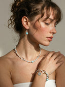 Yue TerraBrio lifestyle banner featuring the Azure Ritual Set: Larimar, Clear Quartz and Pearl necklace, bracelet, and earrings on a model.