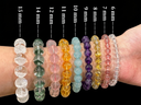 A wrist wearing gemstone bracelets with different bead sizes from 6 mm to 15 mm for the Yue TerraBrio bracelet size guide.