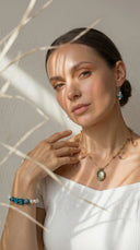 Yuè TerraBrio high-vibrational jewelry featuring a temple-blessed moonstone necklace and larimar crystal earrings. This consecrated jewelry is handcrafted with natural minerals and energized through authentic monastic rituals to serve as a spiritual anchor for inner peace and manifestation.