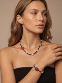 Model wearing the Yue TerraBrio Equilibrium Aura red agate and prehnite bracelet with the matching raw prehnite and carnelian statement necklace.