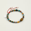 Yue TerraBrio Global Nomad adjustable bracelet with malachite, turquoise, tiger’s eye, warm-toned mineral accents, textured silver details, and a sterling silver tag.
