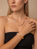 Model wearing the Yue TerraBrio Golden Flow citrine and pearl bracelet styled with a matching gemstone necklace.