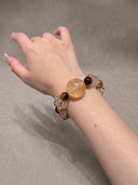 Close-up of the Yue TerraBrio Golden Momentum gemstone bracelet with yellow hematoid quartz, tiger eye, and citrine beads worn on the wrist.