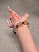 Model wearing the Yue TerraBrio Golden Momentum yellow hematoid quartz, tiger eye, and citrine bracelet on a neutral background.