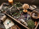 Yue TerraBrio jewelry resting with natural gemstones, dried botanicals, and soft candlelight before the intention ritual.