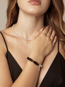 Model wearing the Yue TerraBrio Midnight Poise black agate and freshwater pearl bracelet with a pearl necklace and black outfit.