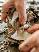 Natural pearl material being handled with care, representing organic beauty and timeless character in Yue TerraBrio jewelry.