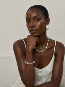 Model wearing Yue TerraBrio pearl and crystal jewelry, highlighting natural materials, modern styling, and symbolic meaning.