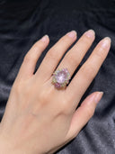 Model wearing the Yue TerraBrio Rose Halo rose quartz adjustable sterling silver ring on a dark fabric background.