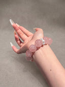 Model wearing the Yue TerraBrio Rose Softness bracelet with rose quartz beads and shell pearls on a soft neutral background.