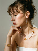 Yue TerraBrio lifestyle banner featuring the Solar Manifestation Set: Brazilian Citrine necklace, bracelet, and earrings on a model.