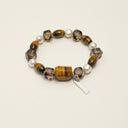Yue TerraBrio Terrane Sovereignty bracelet with hexagonal smoky quartz, tiger’s eye stones, textured accent beads, and a sterling silver logo tag.